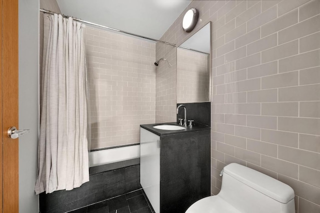 bathroom with vanity, toilet, and tile walls