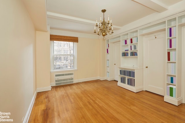 spare room featuring hardwood / wood-style floors, a chandelier, and a wall mounted AC