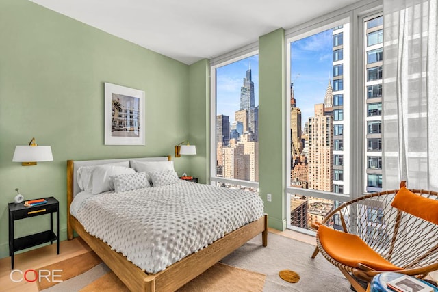 bedroom featuring expansive windows and light colored carpet