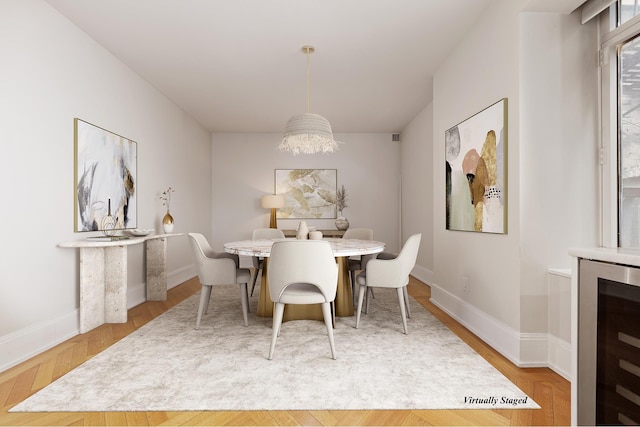 dining area featuring wine cooler, baseboards, and wood finished floors