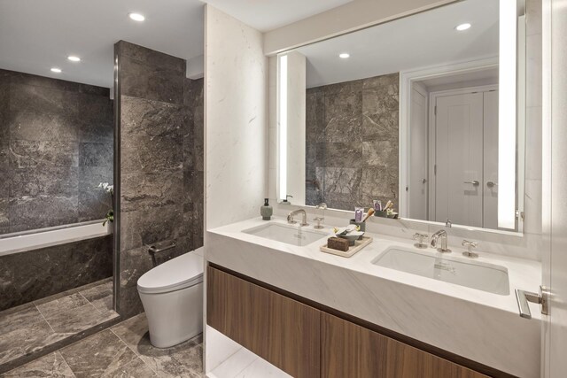 bathroom with vanity, toilet, and tile walls