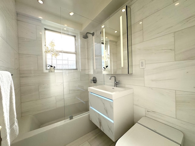 bathroom with shower / tub combination, vanity, toilet, recessed lighting, and tile walls
