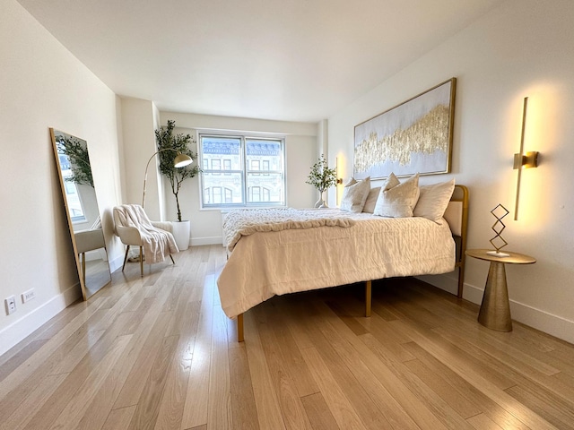 bedroom with baseboards and light wood-type flooring