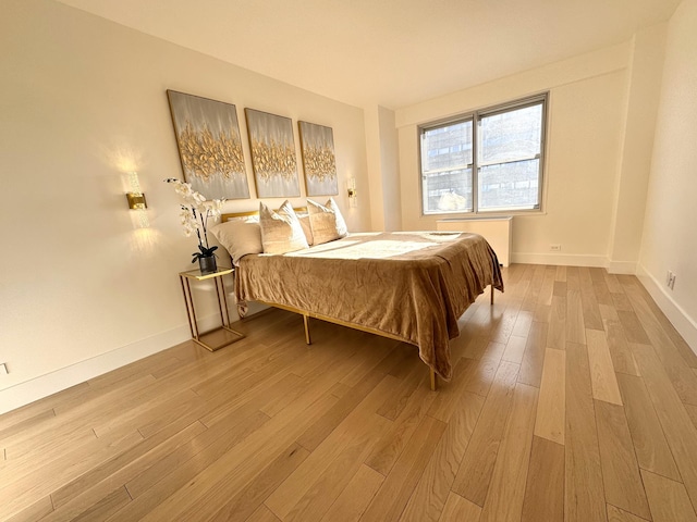 bedroom with light wood-style floors and baseboards