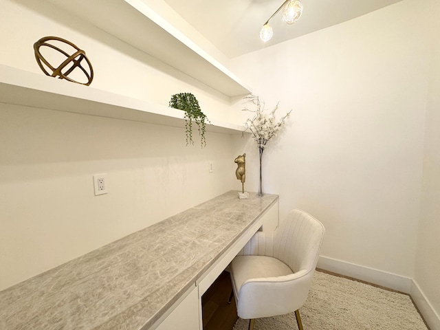 home office featuring baseboards and built in desk