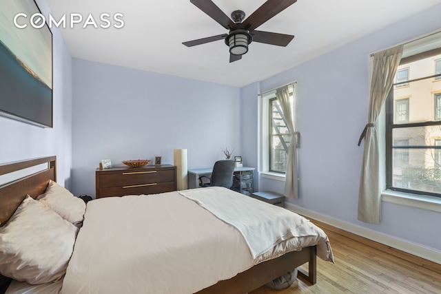 bedroom with ceiling fan, baseboards, and wood finished floors