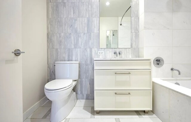 full bathroom with shower / washtub combination, toilet, tile walls, and vanity