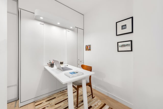 office area with light wood-style flooring and baseboards