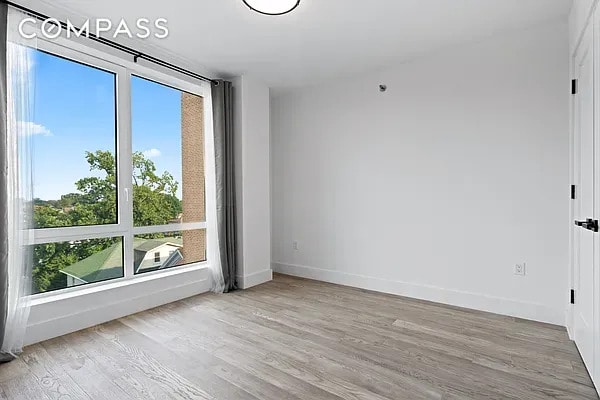 spare room with wood finished floors and baseboards