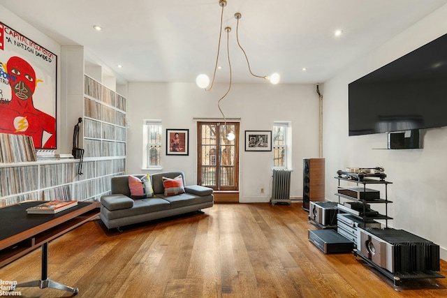 living area featuring radiator, wood finished floors, and recessed lighting