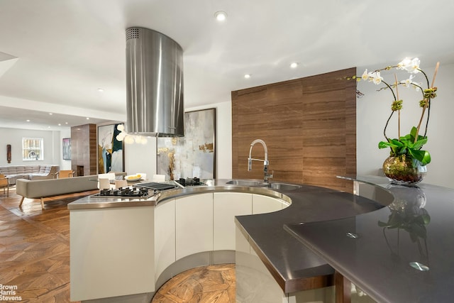 kitchen featuring a sink, stainless steel countertops, modern cabinets, and recessed lighting