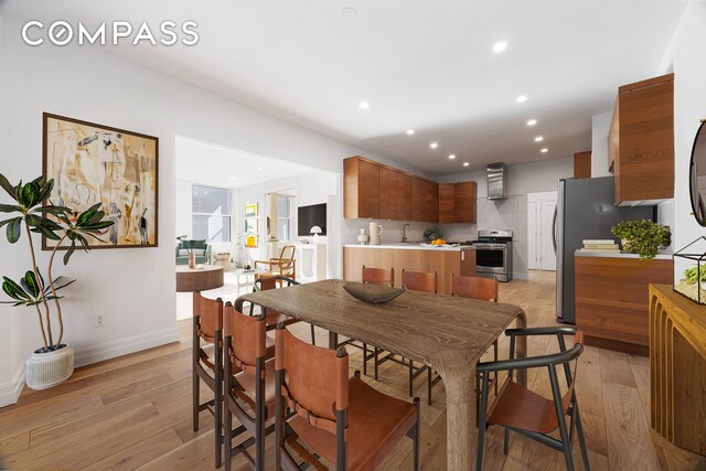 dining area featuring sink and light hardwood / wood-style flooring