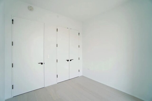 unfurnished bedroom with light hardwood / wood-style floors and a closet