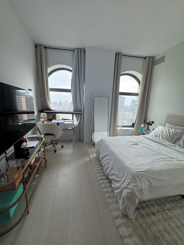 bedroom featuring hardwood / wood-style floors and multiple windows