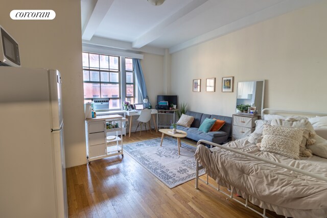 living room featuring beamed ceiling and light wood-type flooring