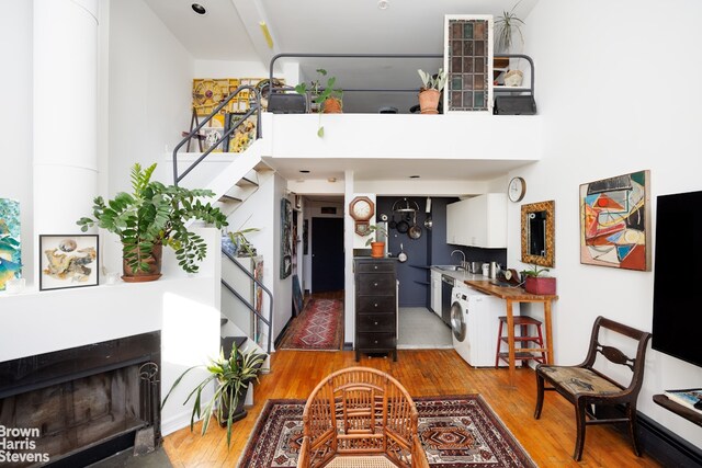 interior space with washer / clothes dryer, stairway, a fireplace, and wood finished floors