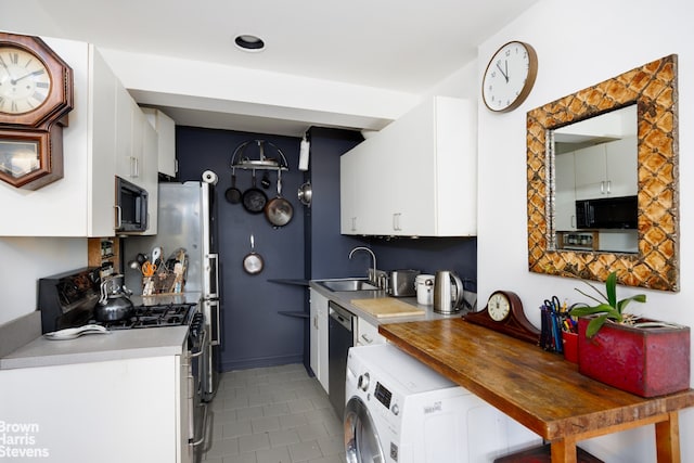 kitchen featuring washer / clothes dryer, white cabinetry, sink, light tile patterned floors, and black appliances