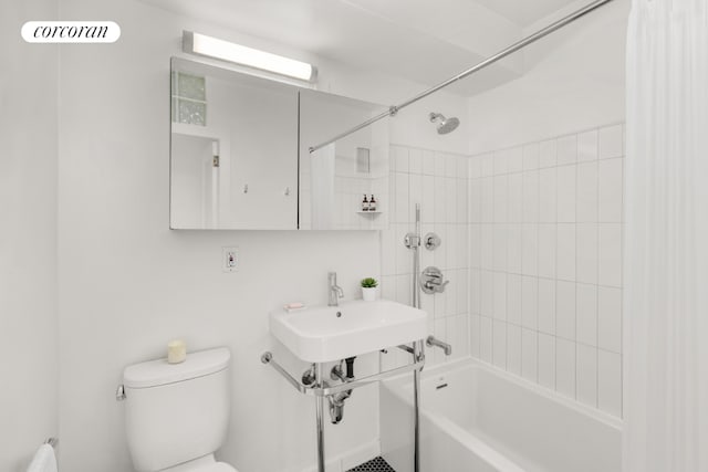 full bathroom with sink, tiled shower / bath, and toilet