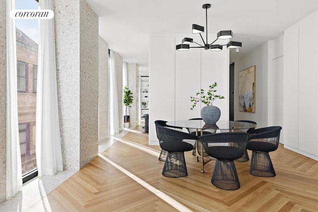 dining room with light parquet flooring and a notable chandelier