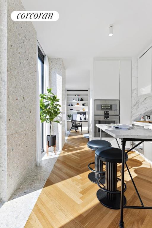 kitchen with parquet flooring, stainless steel double oven, and white cabinets