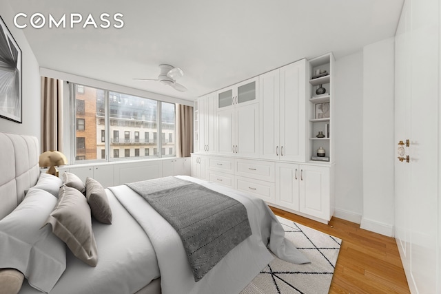 bedroom featuring light wood-style flooring, a ceiling fan, and baseboards