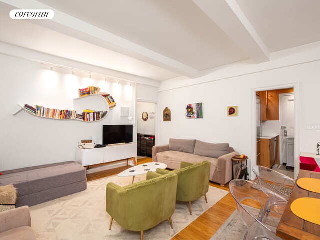 living room featuring beamed ceiling and wood-type flooring