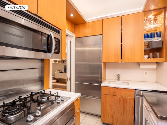 kitchen featuring light tile patterned floors, appliances with stainless steel finishes, a sink, and recessed lighting