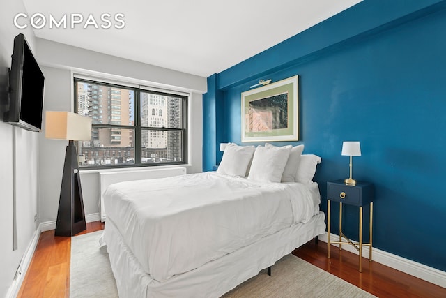 bedroom featuring baseboards and wood finished floors