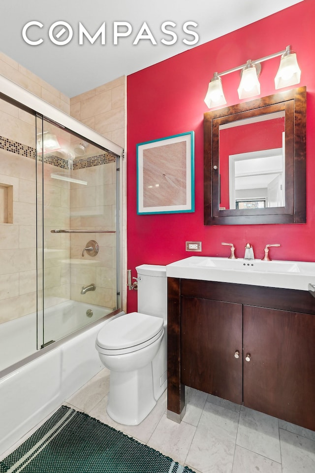 full bath with tile patterned floors, combined bath / shower with glass door, toilet, and vanity