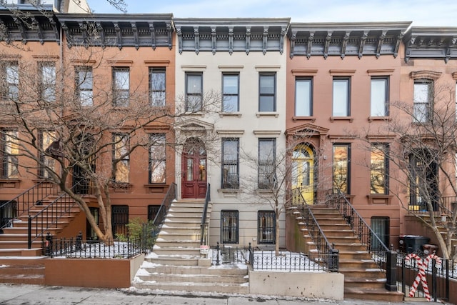 view of property featuring stairs and fence