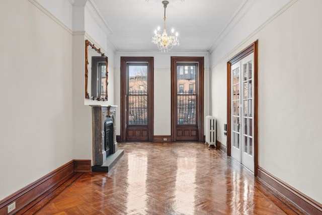 entrance foyer featuring an inviting chandelier, radiator heating unit, baseboards, and ornamental molding