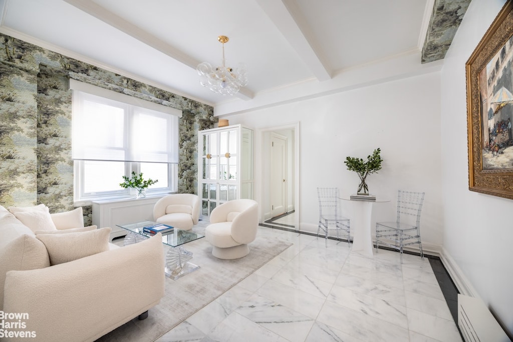 living area featuring beamed ceiling, baseboards, a chandelier, and marble finish floor