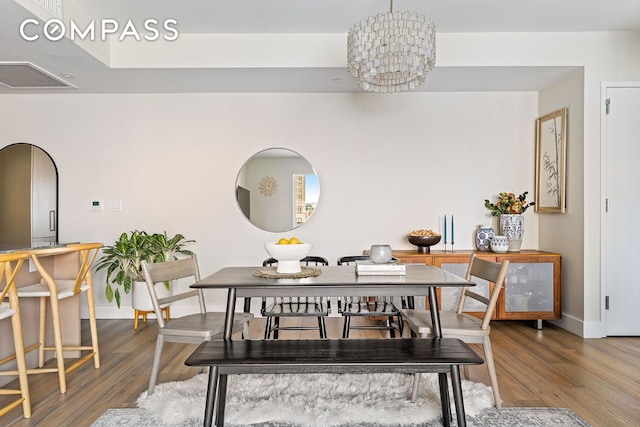 dining room featuring hardwood / wood-style floors and a notable chandelier