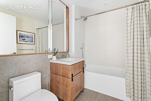 full bathroom with vanity, toilet, shower / tub combo, and tile walls