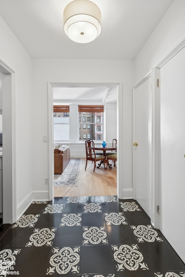 hall featuring wood finished floors and baseboards