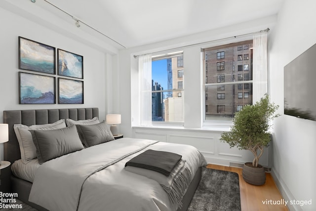 bedroom featuring visible vents, baseboards, and wood finished floors