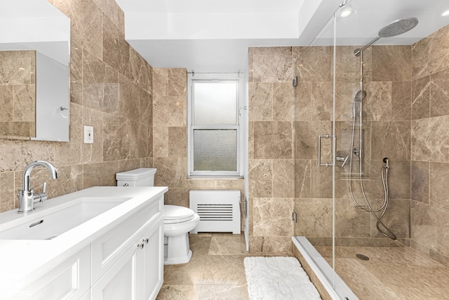 full bath with a stall shower, tile walls, toilet, and vanity