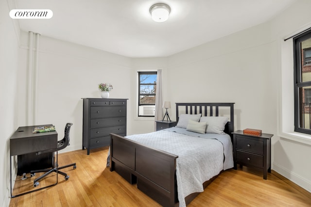 bedroom featuring visible vents, light wood-style flooring, and baseboards