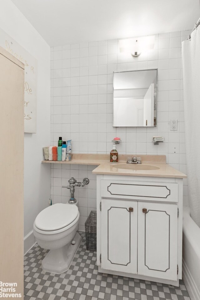 full bathroom featuring shower / tub combo with curtain, vanity, toilet, and tile walls