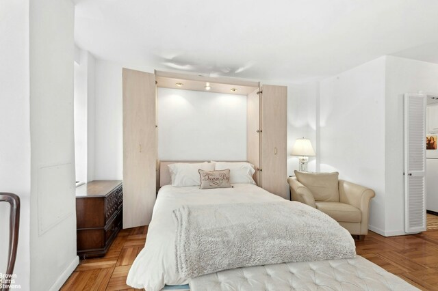 bedroom with light parquet flooring