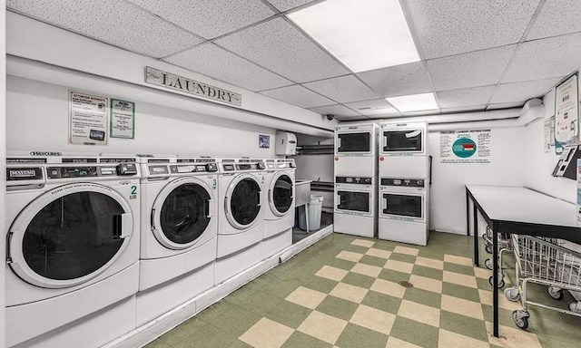 community laundry room with stacked washer / dryer, washer and clothes dryer, and light floors