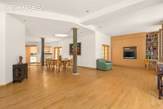 interior space featuring light hardwood / wood-style flooring and decorative columns