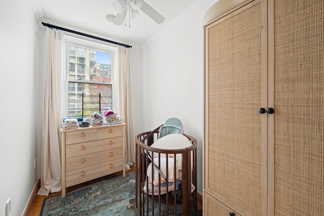 interior space with dark wood-type flooring, crown molding, baseboards, and ceiling fan