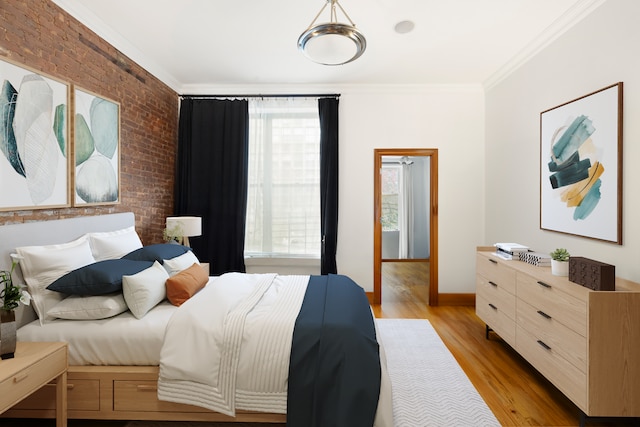 bedroom featuring light wood finished floors, brick wall, ornamental molding, and baseboards