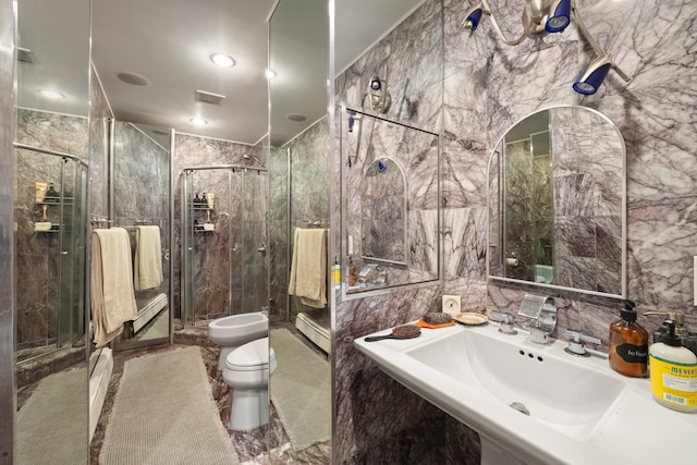 bathroom with tile walls, visible vents, toilet, a sink, and a shower stall