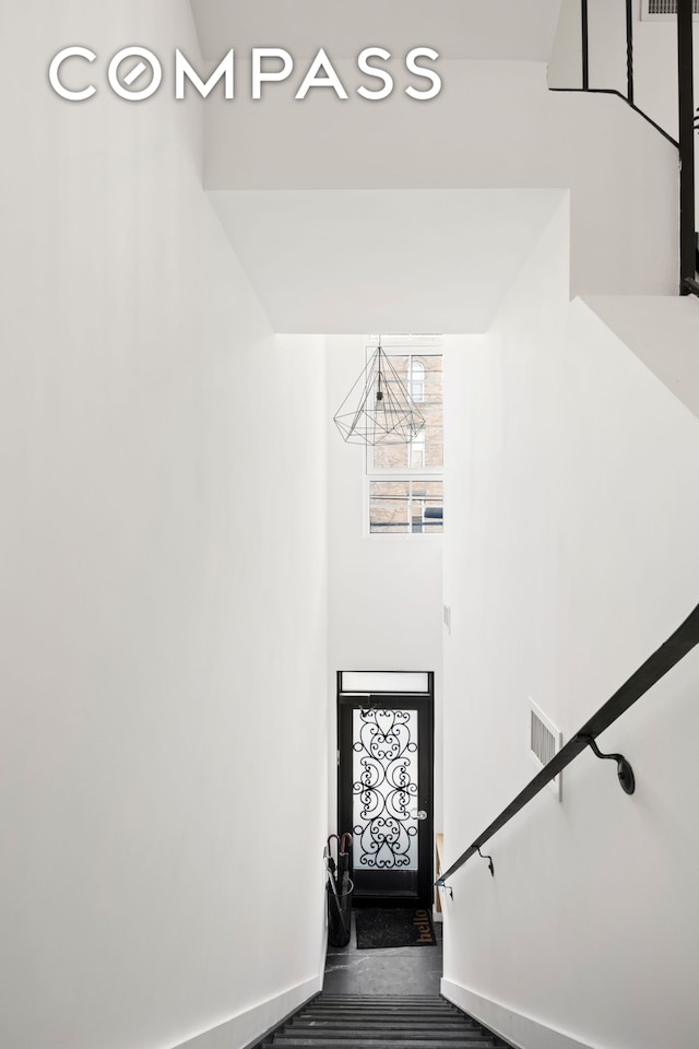 stairs featuring baseboards and a high ceiling