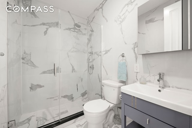 full bathroom featuring vanity, toilet, marble finish floor, and a marble finish shower