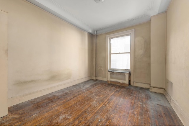 spare room featuring dark wood finished floors and crown molding