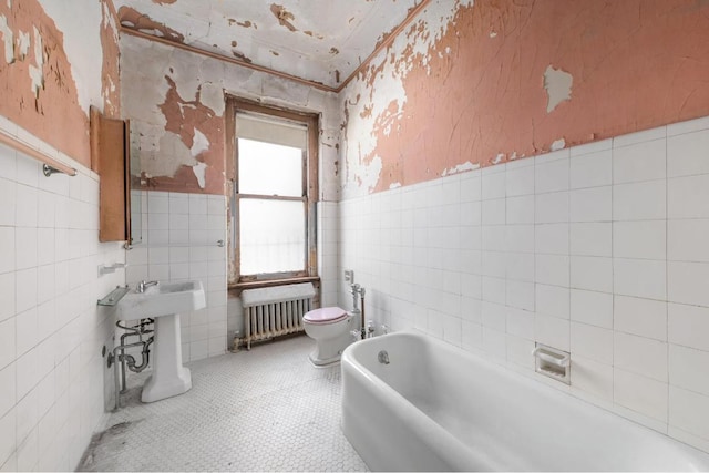 bathroom with radiator, toilet, a bidet, a bath, and tile patterned floors