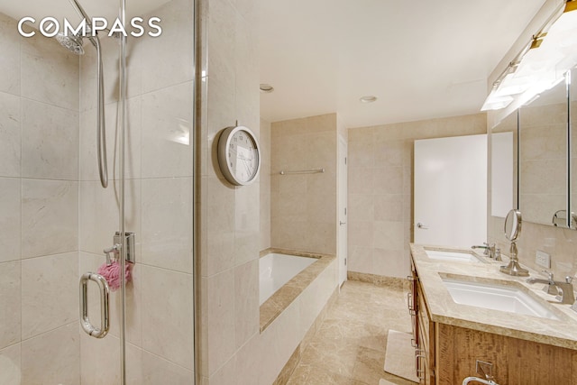 bathroom with a sink, double vanity, a shower stall, and tile patterned floors